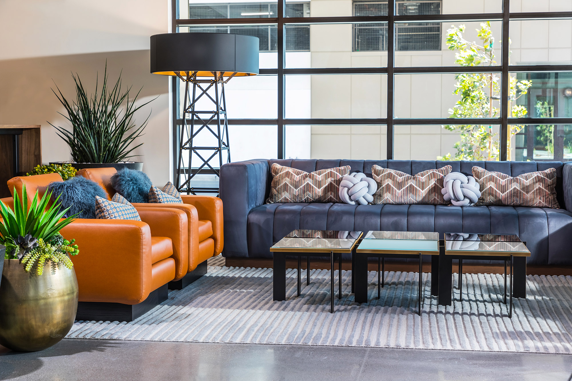 Clubhouse entrance with seating area, designer lighting, and walls of windows.