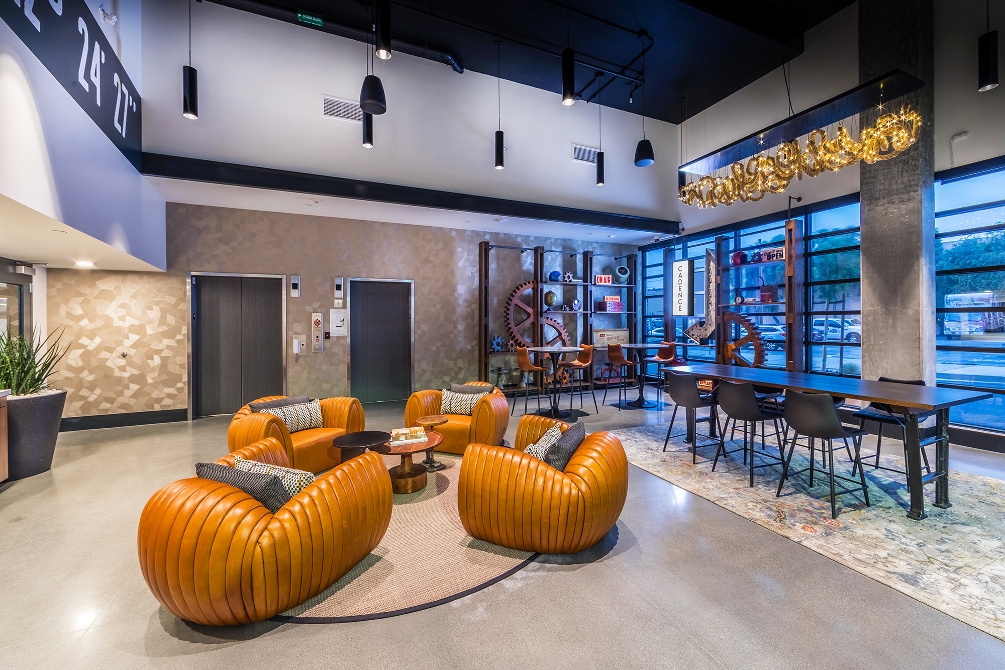 Lobby with modern furniture, coffee table, brick accent wall and retro art.