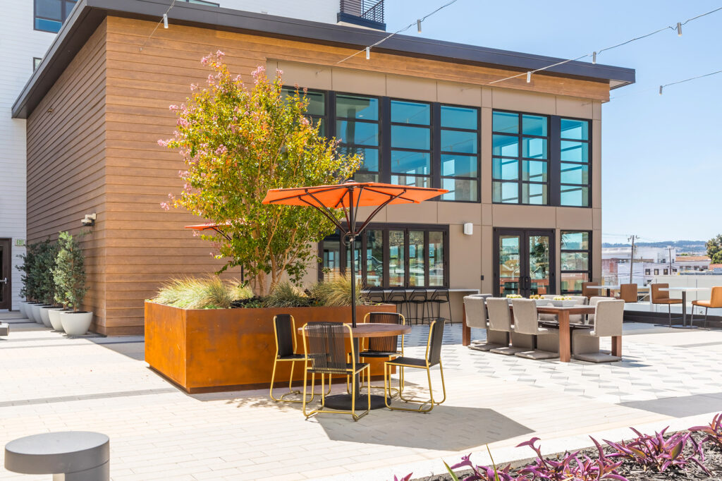 Rooftop area with a variety of seating, patio umbrellas, and stunning views.