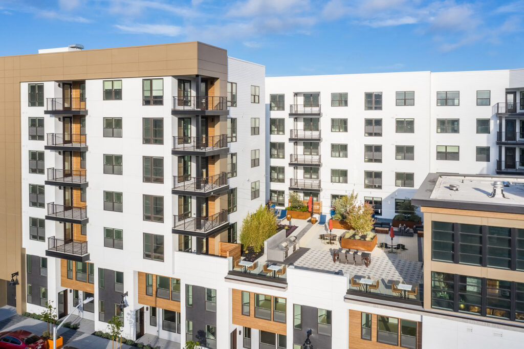 Aerial view of community with rooftop terrace and balconies.