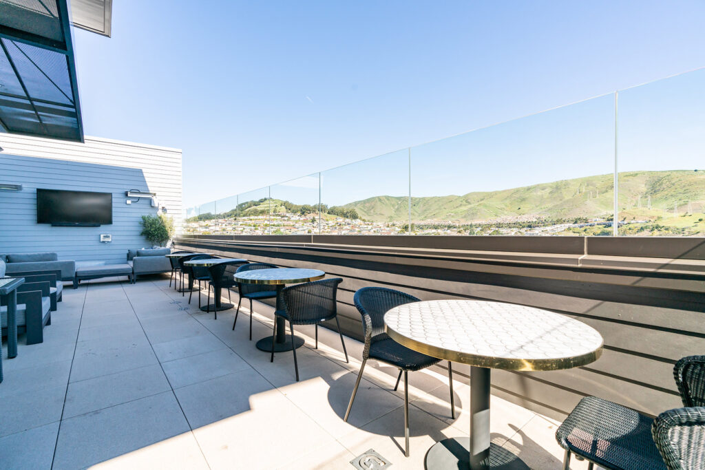 Terrace with table seating, couches, and flat-screen TV.