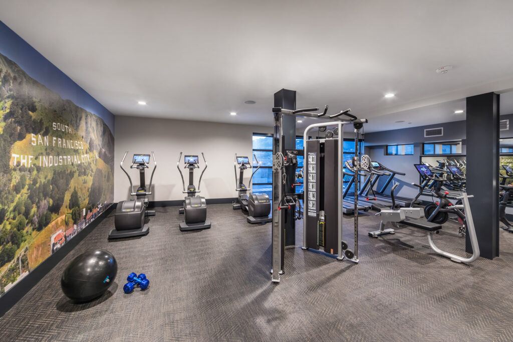 Fitness center with elliptical machines, strength training equipment, treadmills, and mirrors.