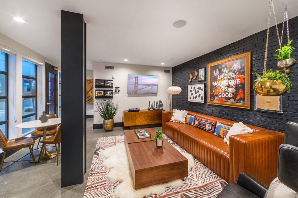 Lobby area with black brick wall, modern furniture, and music inspired art.